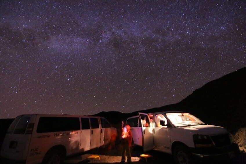 A white van parked under a starry night sky. 3