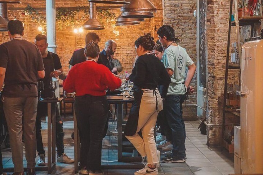 Un gruppo di persone cena in un ristorante con pareti in mattoni e lampade a sospensione. 3