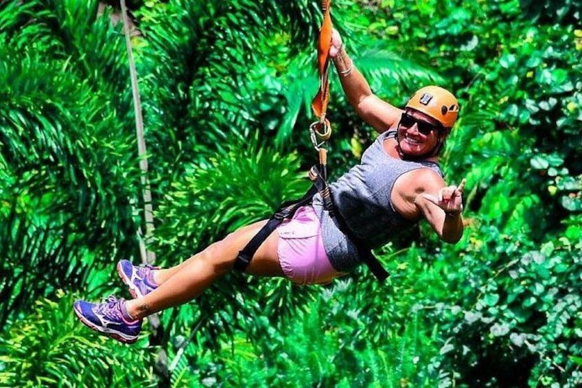 A person zip-lining through a dense, green forest. 3