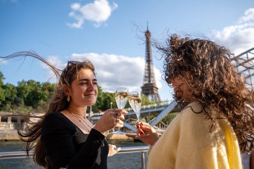 Deux personnes trinquent avec des coupes de champagne, une rivière et la Tour Eiffel en arrière-plan. 3