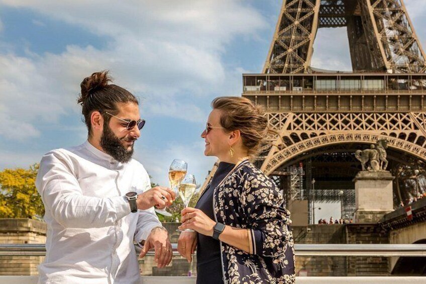 Deux personnes trinquent au champagne devant la Tour Eiffel. 1