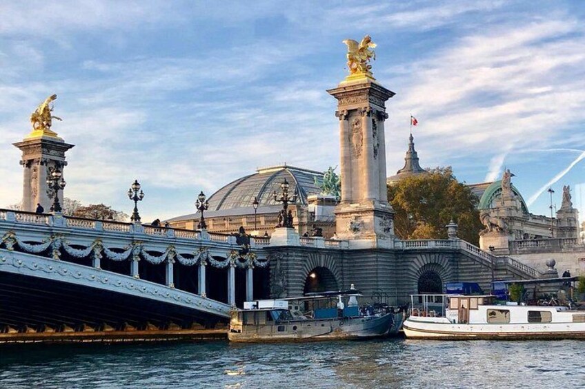 Un pont orné de statues, un bateau et un bâtiment surmonté d’un dôme. 5