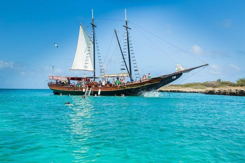 A traditional sailing boat with multiple sails on a turquoise sea. 2