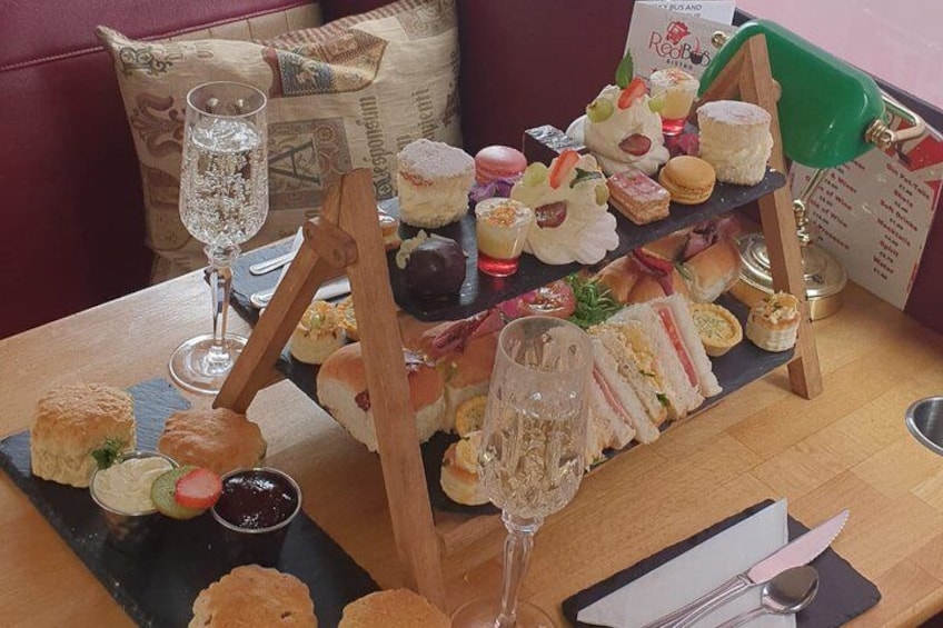 A table with a variety of sandwiches, pastries, and a glass of water. 5