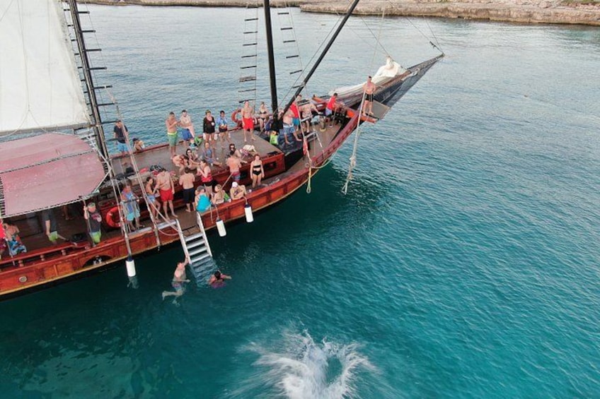 A large boat with people on board, docked at a calm body of water. 2