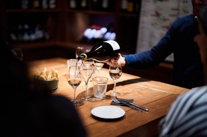 Una persona sirve vino en un vaso en un bar. 5