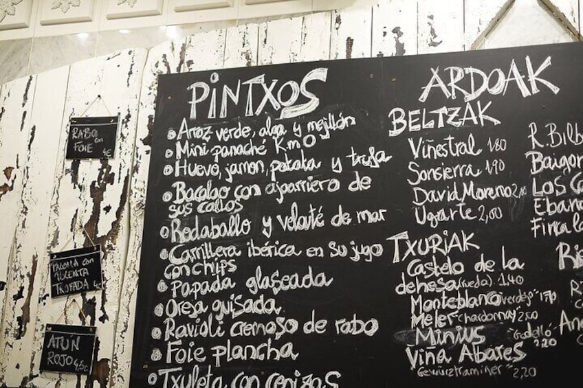A chalkboard menu with various food items and prices. 3