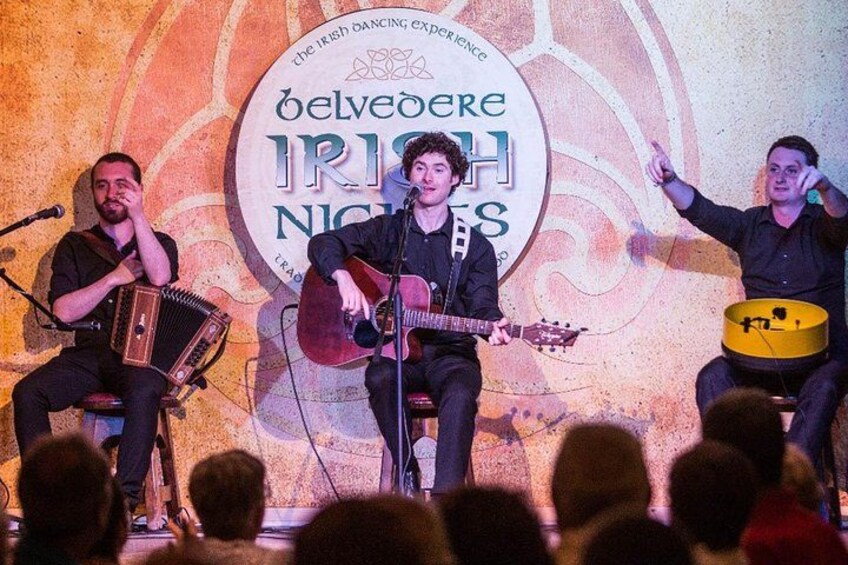 Un groupe joue sur scène, avec une toile de fond sur laquelle on peut lire : « Soirées irlandaises au Belvedere ». 2