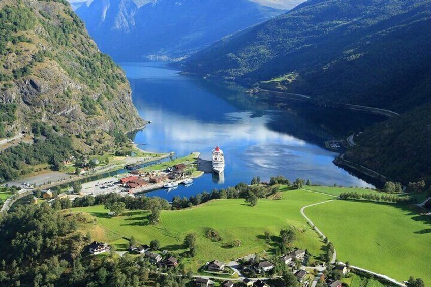 A fjord with a lighthouse, green fields, and a mountainous landscape. 5