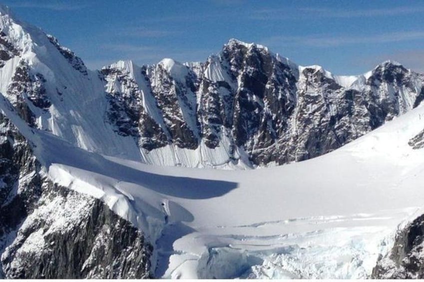 Una catena montuosa innevata con cime appuntite e un ghiacciaio. 2