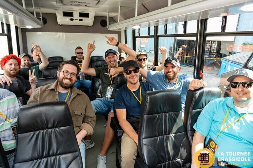 A group of people seated inside a bus, with some raising their hands. 4