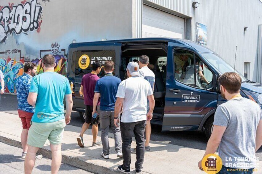 A group of people standing in front of a blue van with 'LA TOURNÉE BRASSICHE' written on it. 5