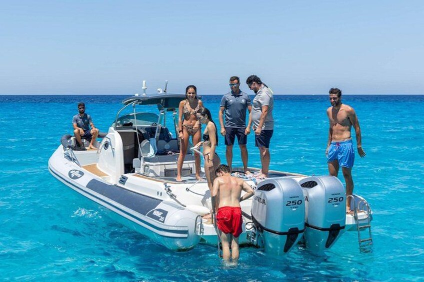 A group of people on a boat in clear blue water. 2