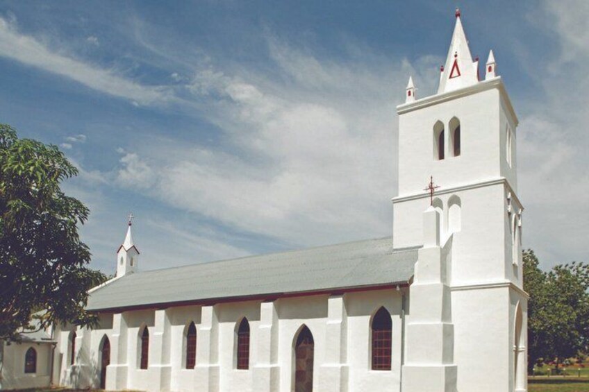 A white church with a bell tower and arched windows. 3