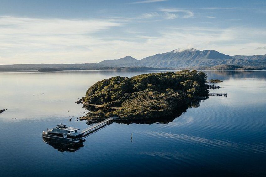 Un lac paisible avec une petite île, un quai et des montagnes en arrière-plan. 2