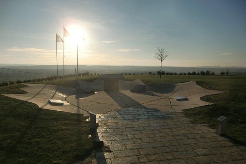 A skate park with ramps and a paved walkway. 3