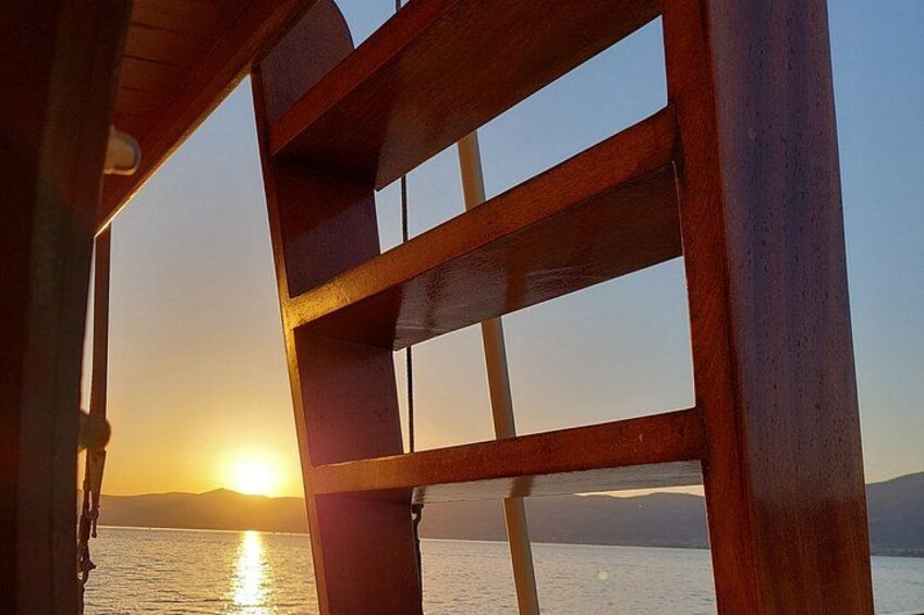 A wooden structure with a view of the sunset over water. 5
