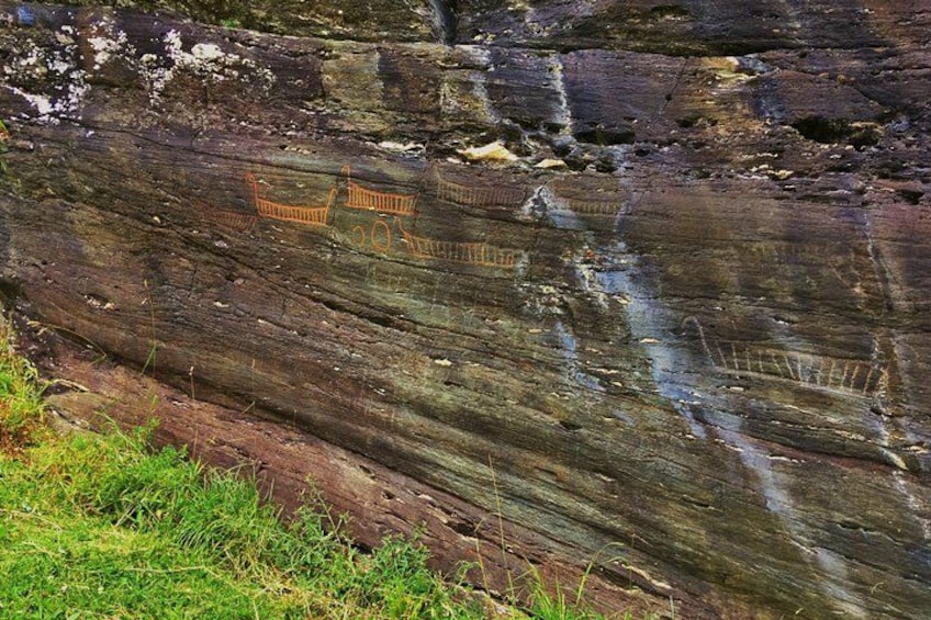 A rock with ancient carvings of a boat and figures. 3