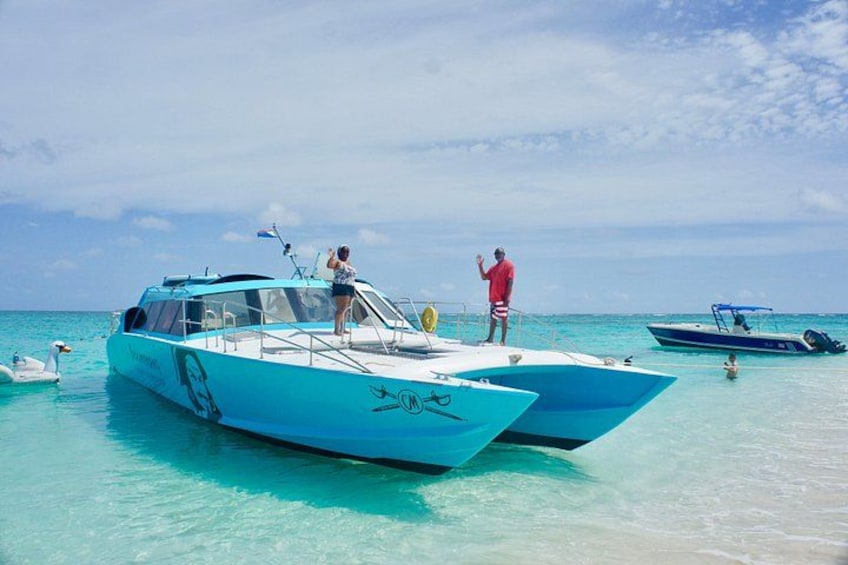 A blue boat with people on it, another boat in the background, and a clear blue sea. 4