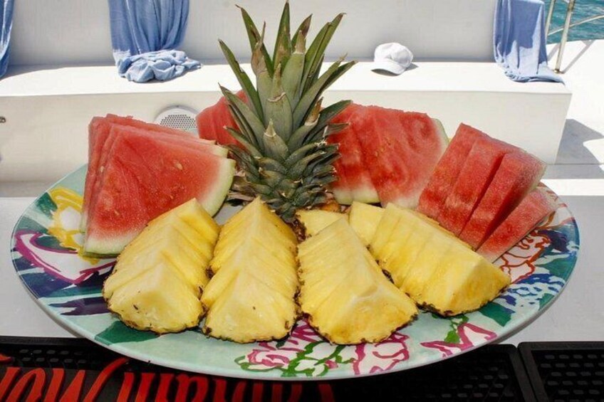 Une assiette de tranches de pastèque et d’ananas sur un bateau. 2