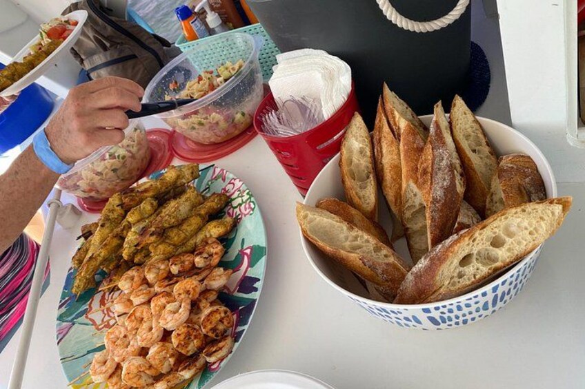 A table with food items including shrimp, bread, and a salad. 3