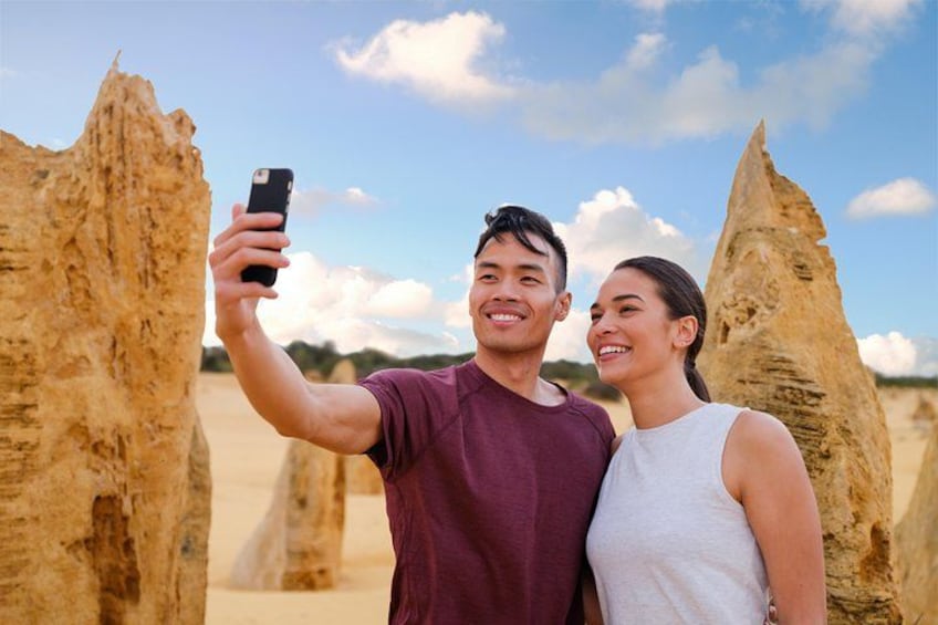 Una pareja tomándose un selfie con una formación rocosa de fondo. 4