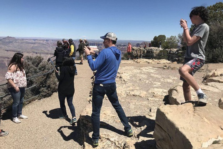 Un groupe de personnes se tient sur un promontoire rocheux, d’où l’on peut admirer un canyon. 5