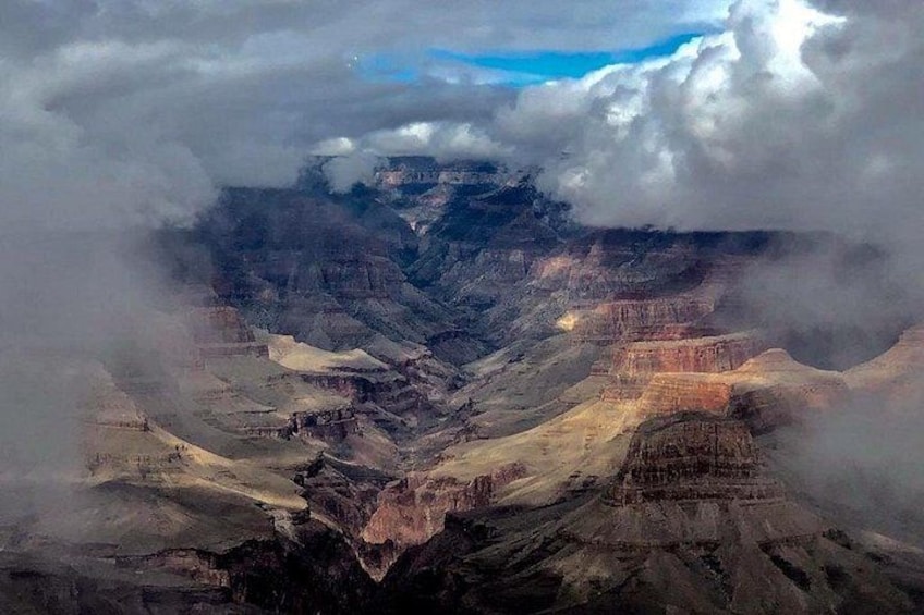 Un canyon aux formations rocheuses en strates et un ciel nuageux. 2