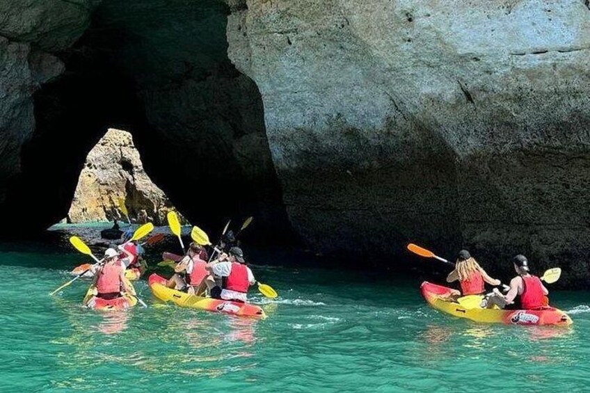 Un grupo practica kayak en la entrada de una cueva rodeada de formaciones rocosas. 4