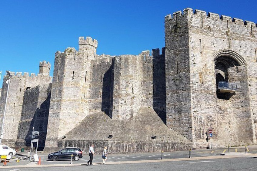 A historic stone castle with multiple towers and a large arched entrance. 5