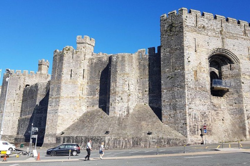 A historic stone castle with multiple towers and a large arched entrance. 3