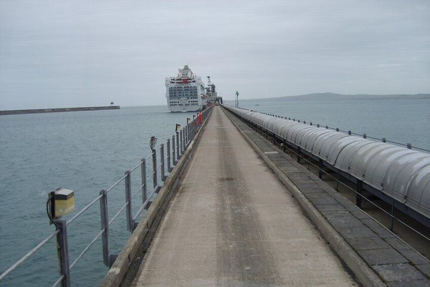 A bridge over water with a cruise ship in the distance. 3