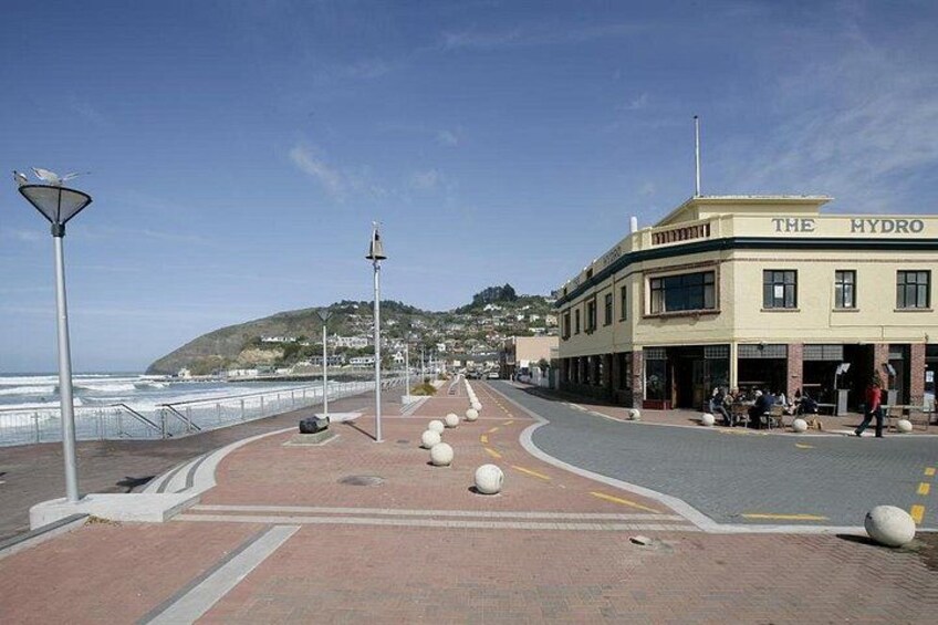 Un paseo marítimo con un edificio identificado como 'The Hydro', un sendero pavimentado y vistas al mar. 3