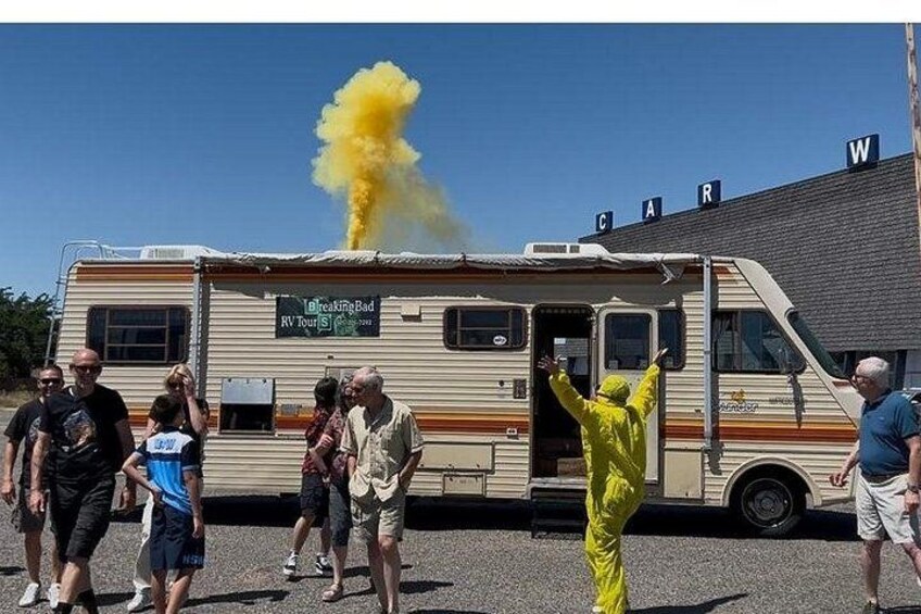 A yellow hazmat suit person, a RV, and a yellow smoke plume. 2