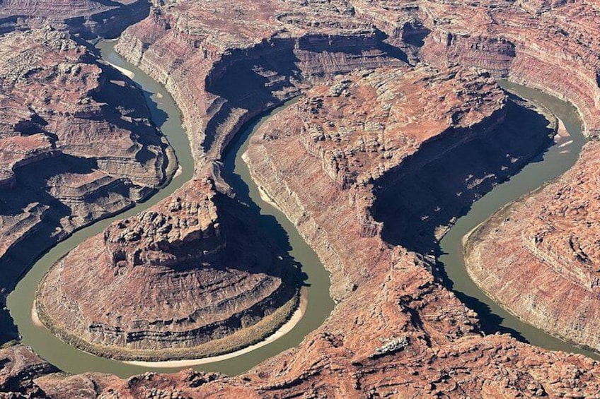 A river winding through a canyon with layered rock formations. 1