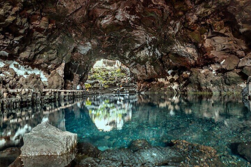 A cave with a clear pool reflecting the rocky interior. 4