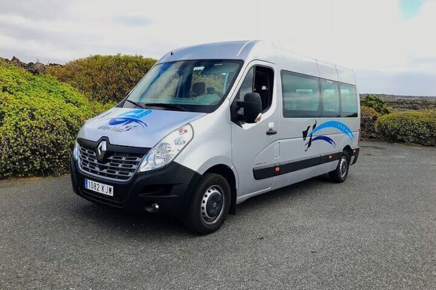A white Renault van with a blue and black logo on the side parked on a road. 5