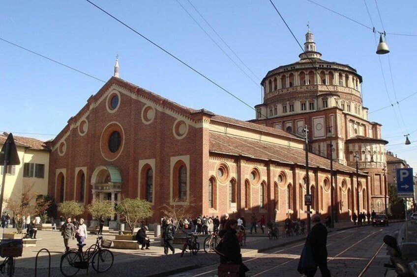 A historic building with a dome and arched windows, surrounded by pedestrians and bicycles. 4