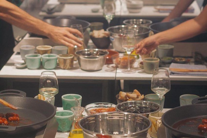 Una cocina con varios utensilios de cocina, tazones y vasos sobre la encimera. 3