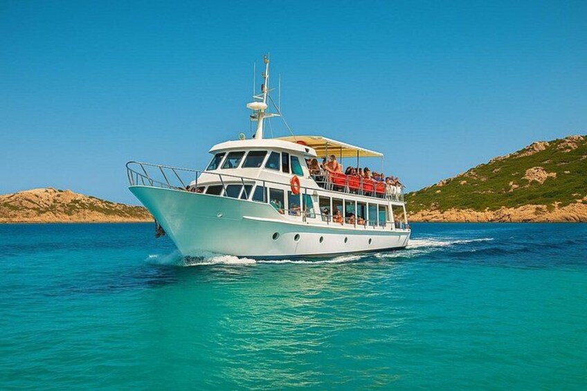 Ein weißes Boot mit Passagieren auf einem türkisblauen Meer, umgeben von felsigen Hügeln. 3