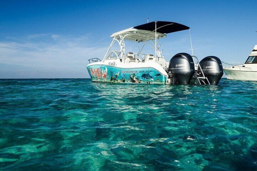 A boat with two Yamaha engines, a canopy, and a colorful design on the side. 2