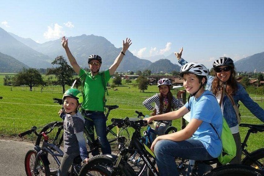 A group of people on bicycles in a rural landscape with mountains in the background. 3