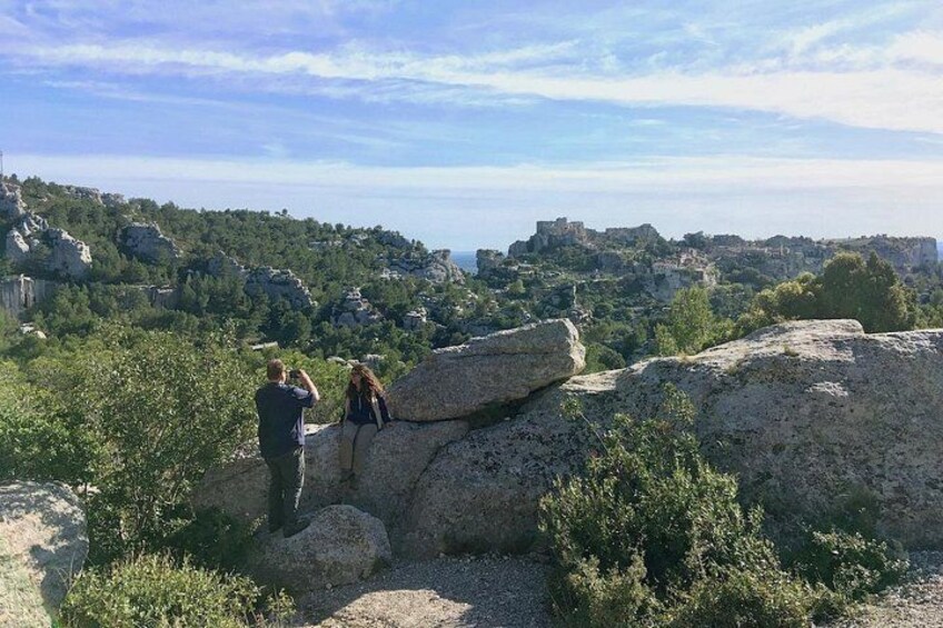 Two people observing a landscape with rocky terrain and a distant view of a town. 2
