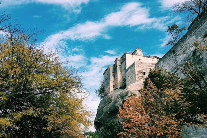 A historic stone building perched on a cliff with autumn foliage. 3