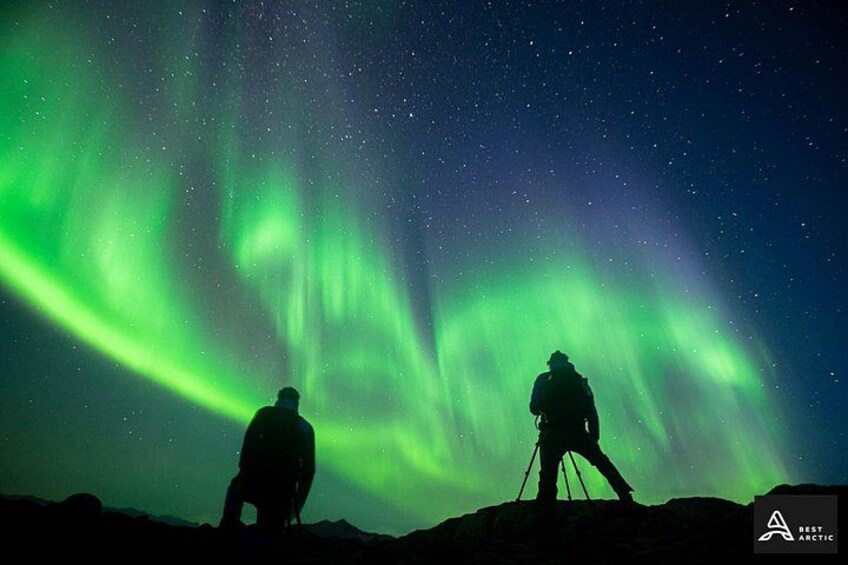 Two people observing the Northern Lights in a dark sky. 5