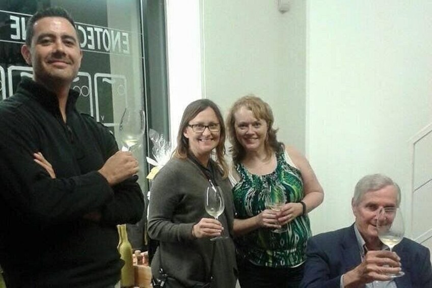 Un groupe de personnes se trouve à l'intérieur, et certaines d'entre elles tiennent des verres à vin. 2