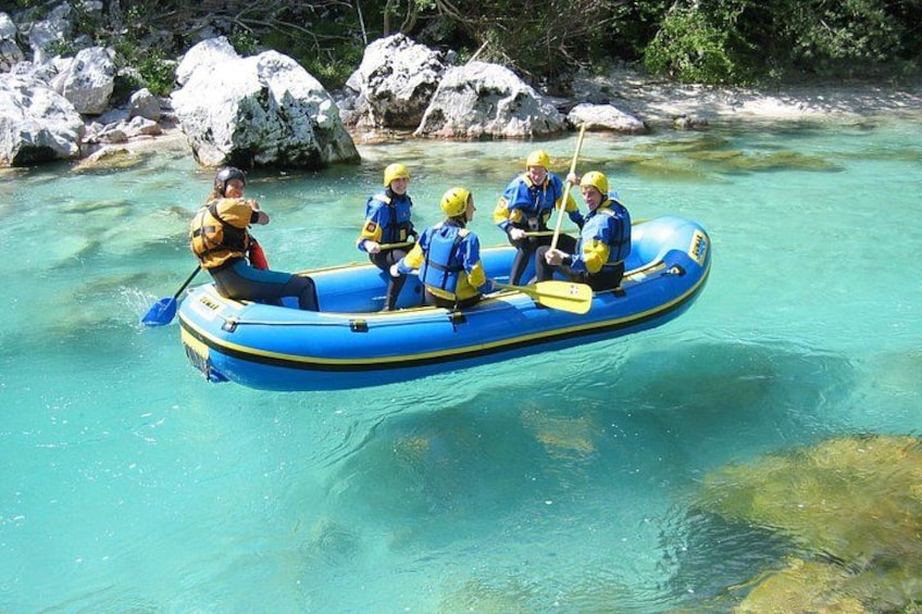 Un groupe de personnes se trouve dans un radeau gonflable bleu, sur une rivière aux eaux claires, entourée de rochers. 3