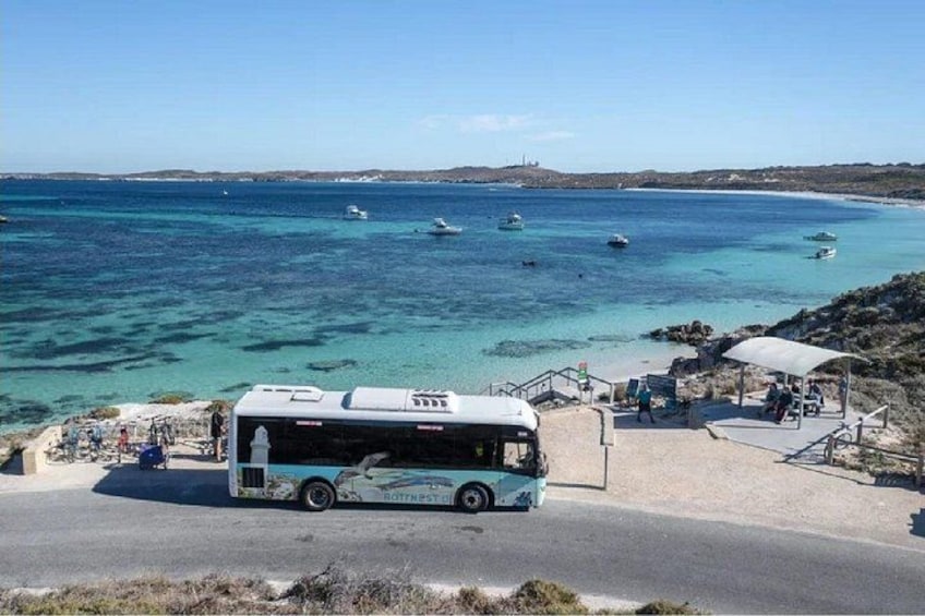 A bus at a coastal bus station with a view of the sea and boats. 3