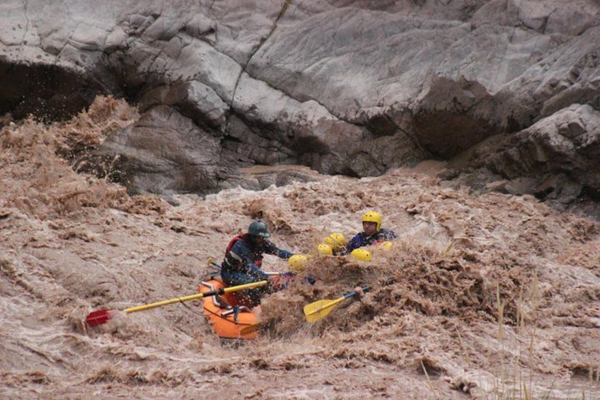 Two kayakers navigating through a muddy river. 2