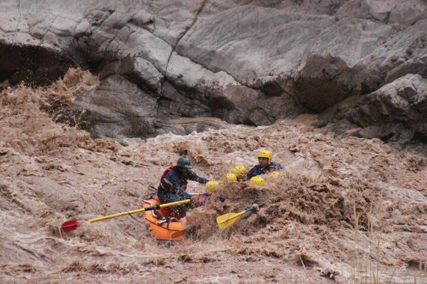 Two people kayaking through a muddy river. 2